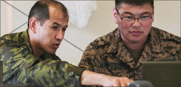 A Tajik National Army officer (left) and a Mongolian Army officer (right) evaluate a simulated event  during command post exercise Regional Cooperation 18 at Camp Edwards on Joint Base Cape Cod, Massachusetts, Sept. 15, 2018. Regional Cooperation is an annual exercise conducted by multiple national partners focusing on stability operations, border security and control, counter terrorism, counter narcotics,  and counter proliferation.