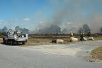 Fire personnel watch as the burn continues
